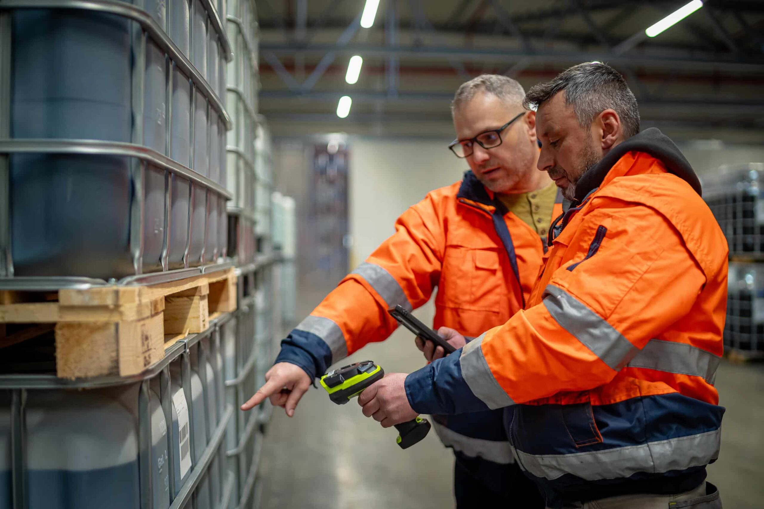 Twee logistiek medewerkers controleren ADR-goederen bij geconditioneerde opslag voor temperatuurgevoelig transport.